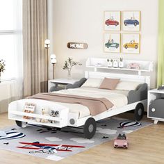 a child's bedroom with a car bed and toy cars on the rugs