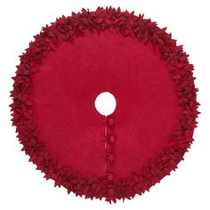 a round red rug with leaves on it and a white circle in the middle that has a button at the center