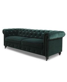 a green velvet couch with studding on the arms and back, in front of a white background