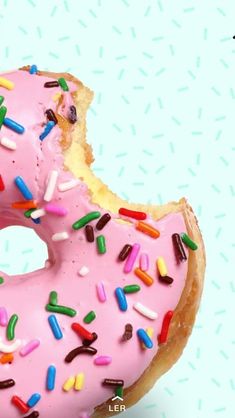 a pink frosted donut with sprinkles on it's side