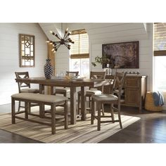 a dining room table and chairs in front of a window