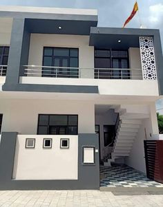 a white and grey house with stairs leading up to it