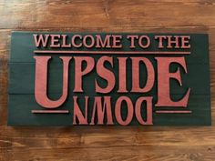 a wooden sign that says welcome to the upside down moo on it's side