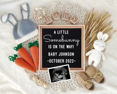 a baby announcement surrounded by toys and crochet on a white blanket with the words'a little something is on the way '