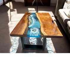 a coffee table made out of wood and glass with water running down the center piece