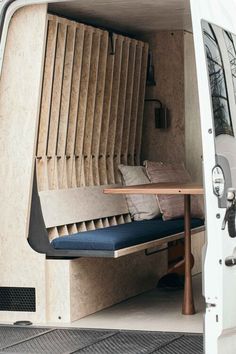 the interior of a camper van that has been converted into a couch and table