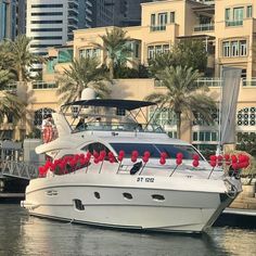 a white boat is in the water with red decorations on it's front end