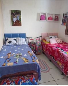 two beds in a room with pictures on the wall