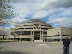 a man standing in front of a large building with a dome on it's roof