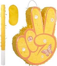 a yellow hand with flowers on it next to a pen