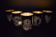 five lit candles in the shape of letters and numbers on black paper with white dots