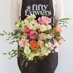 a woman wearing an apron holding a bouquet of flowers in her hands with the words fifty flowers written on it