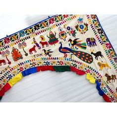 an elaborately decorated wall hanging on the side of a white building with colorful decorations