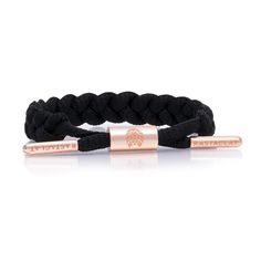 Women's black braided bracelet featuring electroplated peach gold hardware and laser etched emblems. -Hand-braided and assembled for a truly custom and one-of-a-kind experience-Adjustable closure to fit a variety of shapes, sizes and ages-Patented barrel for comfort and style-One size fits most smaller wrists, 4.5" to 6" in wrist circumference-100% polyester feels soft and comfortable against your skin 1% of net proceeds from all Rastaclat sales are donated to the Seek The Positive Foundation. Rastaclat Bracelet, Shoelace Bracelet, Crystal Drinkware, Lace Bracelet, Braids For Black Women, Braided Bracelet, Bracelet Collection, Gold Collection, Custom Bracelets