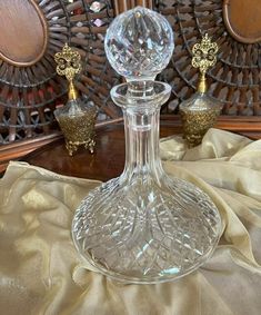 a clear glass vase sitting on top of a table next to two golden candlesticks