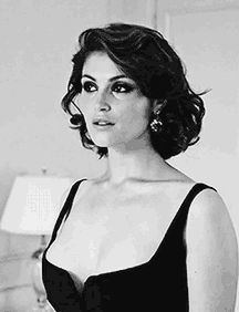 a black and white photo of a woman with short hair wearing a strapless dress