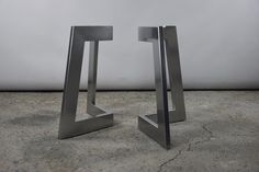 pair of modern steel bookends on concrete floor