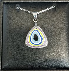 This necklace is made from semi truck fordite from Ohio. It's in a top domed triangle with a flat back. This is a nicely sized piece with great color and patterns.The bail that secures the fordite and the included 20 inch chain are stainless steel. The fordite measures about 19 mm tall. See the pictures for scale next to a nickel. Necklace holder not included. Fordite is recycled automotive paint sourced from automotive factories as well as manufacturers who paint parts for new vehicles. It forms in thin layers as car parts are painted on the racks that hold them in place. After hundreds of trips through the booth where the paint is sprayed and then baked the excess buildup is scraped off the racks. We buy this waste paint in rough chunks and recycle it into beautiful jewelry. It can take Artisan Jewelry Necklaces, Automotive Paint, Necklace Holder, Vehicle Paint, Semi Truck, Handcrafted Artisan Jewelry, Semi Trucks, Car Manufacturers, Necklace Jewelry