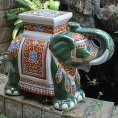 an elephant statue sitting on top of a brick wall