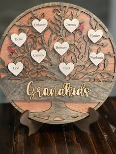 a wooden family tree with names and hearts on the top, sitting on a table