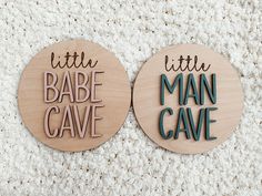 two wooden magnets with words on them that say little babe cave and man cave