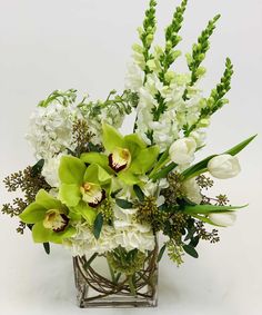 a vase filled with white and green flowers