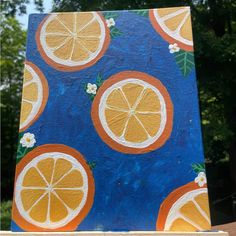 a painting of oranges on a blue background