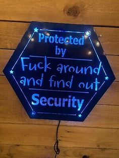 a neon sign that says protected by truck around and find out security on the wall