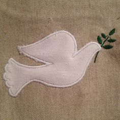 a white dove with a green twig on it