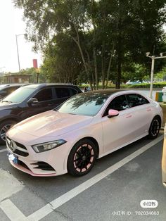 a white car parked in a parking lot next to other cars