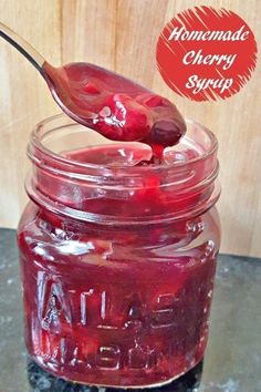 homemade cherry syrup in a mason jar with a spoon