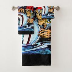 two towels hanging on a towel rack in front of a white wall with an artistic painting