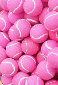 a pile of pink tennis balls sitting next to each other