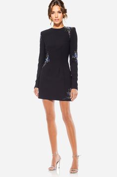 Catching feelings in The Camryn… Who doesn’t love a LBD with some sparkle? We certainly do. The Camryn is the definition of a perfect party dress. Whether you're attending a cocktail party, Thanksgiving, or even Hanukkah, this black mini dress will keep you cozy and feeling like the chicest woman in the room. Its shoulder pads and long sleeves create a polished look, and the embellishments scattered around elevate the dress to a luxurious level. The tulle underskirt adds a subtle throwback bell Fitted Evening Dress For Holiday Party, Embellished Dress For Date Night And Party Season, Embellished Cocktail Evening Dress For Spring, Spring Embellished Cocktail Evening Dress, Spring Embellished Cocktail Dress, Spring Cocktail Evening Dress Embellished, Chic Embellished Fitted Evening Dress, Chic Fitted Evening Dress For Holiday Party, Elegant Embellished Mini Dress For Date Night