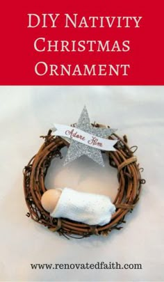 a nativity christmas ornament with a star on top and a wreath around it