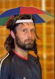 a man with a multicolored umbrella on his head