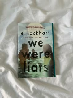 the book we were liars by e lock hart is laying on a white sheet