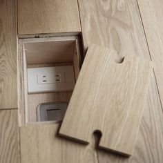 a piece of wood that is laying on the floor with an electrical outlet in it