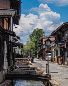 an empty street with buildings and water in the middle