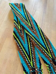 a pair of blue and brown beaded bracelets sitting on top of a wooden floor