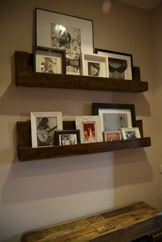 two wooden shelves with pictures and frames on them