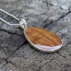 "Pendant size: 41mm x 24mm Thickness: 3mm Metal: Rhodium Plated on Brass Material: Genuine Hawaiian Koa Wood 18\" Silver-Colored Box Chain Included" Teardrop Pendant Necklace With Silver Chain For Gifts, Silver Chain Necklace With Teardrop Pendant For Gift, Oval Silver Chain Necklace Gift, Silver Chain Necklace With Oval Shape For Gift, Oval Silver Chain Necklace For Gift, Teardrop Silver Chain Necklace As Gift, Sterling Silver Brown Necklace For Gift, Brown Teardrop Necklace For Gifts, Brown Teardrop Necklace For Gift