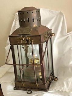 an old fashioned lantern is sitting on a white sheet