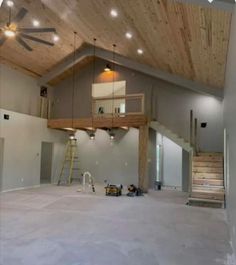 an empty room with a ceiling fan and stairs