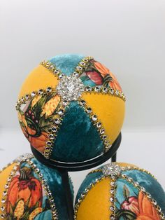 three brightly colored balls are stacked on top of each other, with beaded accents