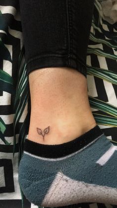 a woman's ankle with a small butterfly tattoo on her left side ribcage