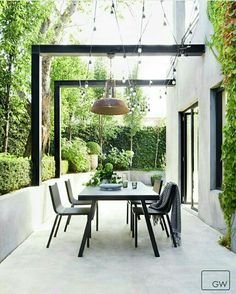 an outdoor dining area with white walls and black chairs is featured in the magazine's website