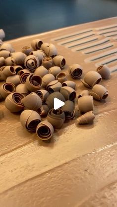 a bunch of rolled up toilet paper sitting on top of a wooden table next to a knife