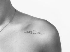 a black and white photo of a man's chest with a tattoo on it