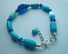 This ocean blue bracelet is 7.5" inches in length and has a 1" inch extender to lengthen the bracelet. The ocean blue beads range in color from a light blue to a deep ocean water blue. A perfect bracelet if you have a slightly larger wrist. It adjusts from 7.5 to 8.5" inches. The clasp is sterling silver. Gift box included.  For personalization: Choose up to 2 letters (initials of a name) XO  etc. Blue Bracelets With Extender As Gift, Blue Beaded Bracelets With Lobster Clasp, Blue Beaded Bracelets With Extender, 2 Letter, Blue Beaded Bracelets, Water Blue, Deep Ocean, Ocean Water, Blue Bracelet